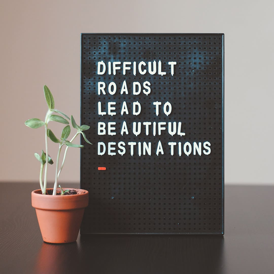 Board with the text: DIFFICULT ROADS LEAD TO BEAUTIFUL DESTINATIONS